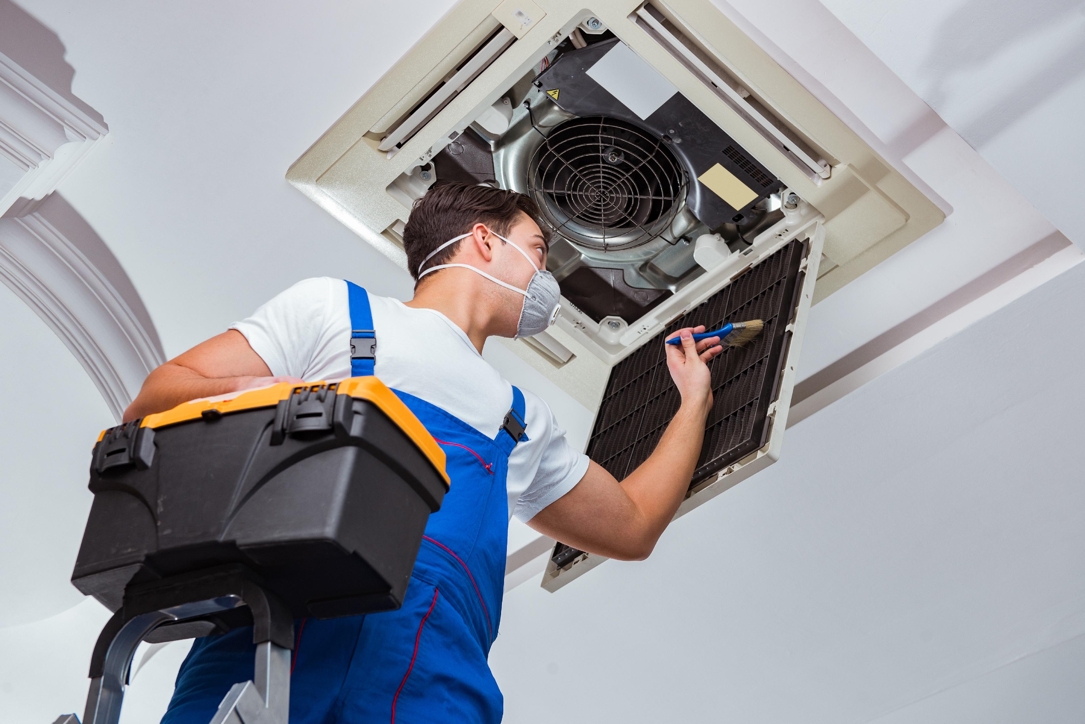 worker-repairing-ceiling-air-conditioning-unit